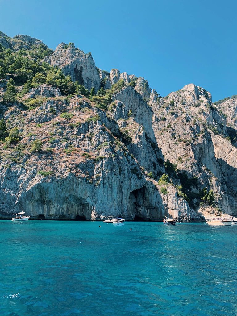 Breathtaking view of hills and clear blue waters in Capri, perfect for summer travel.