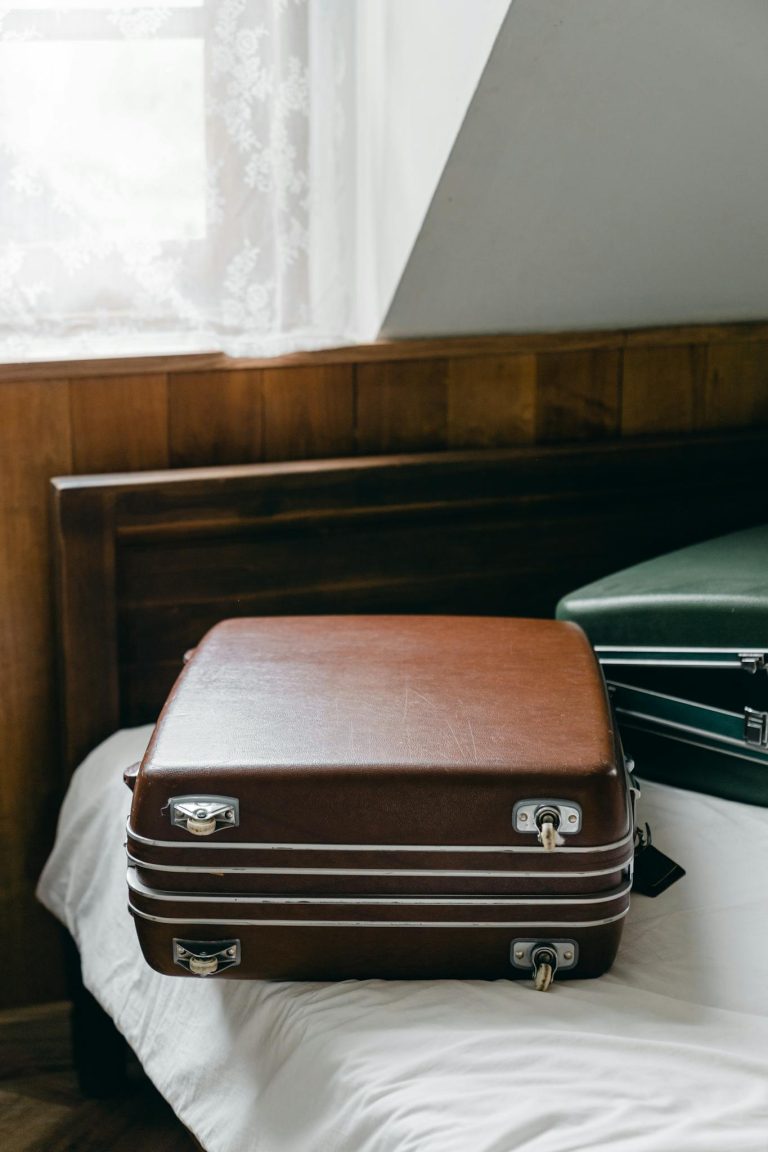 Elegant brown suitcase on bed, capturing cozy travel vibe.